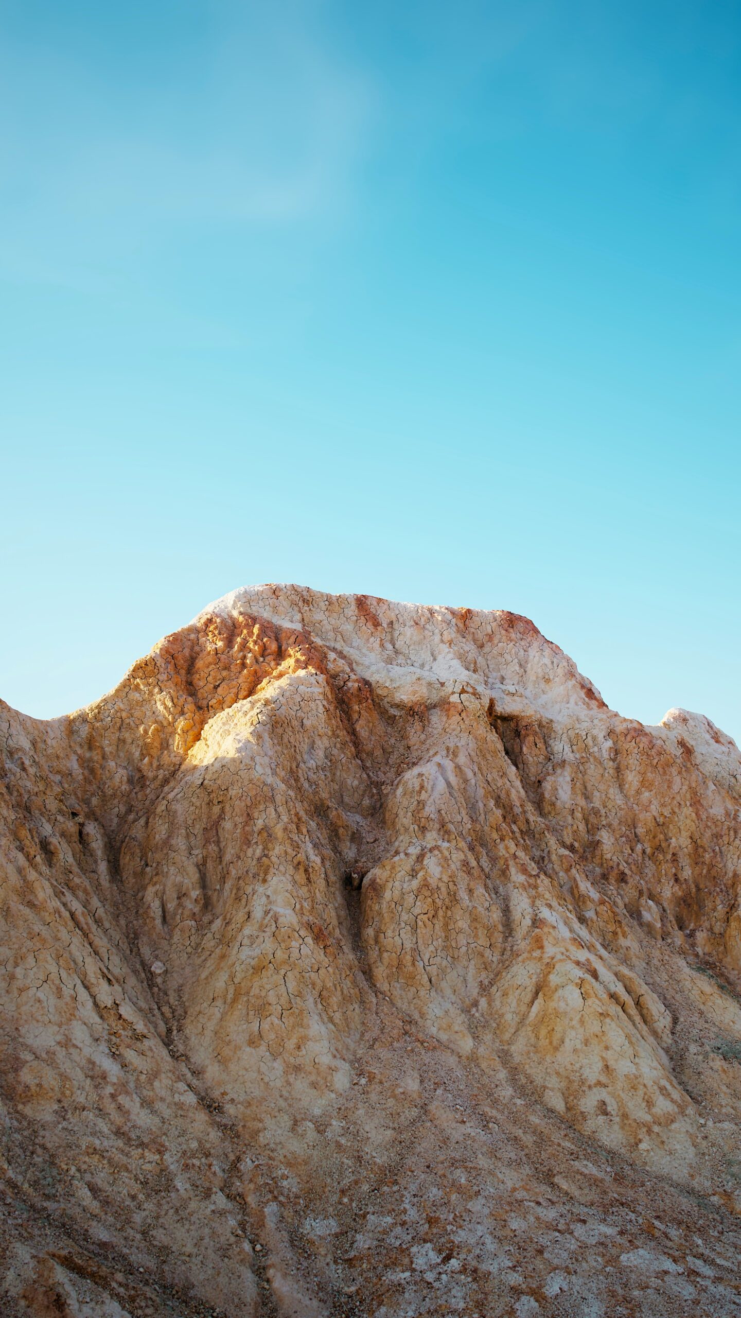 A view of a mountain range with a blue sky in the background