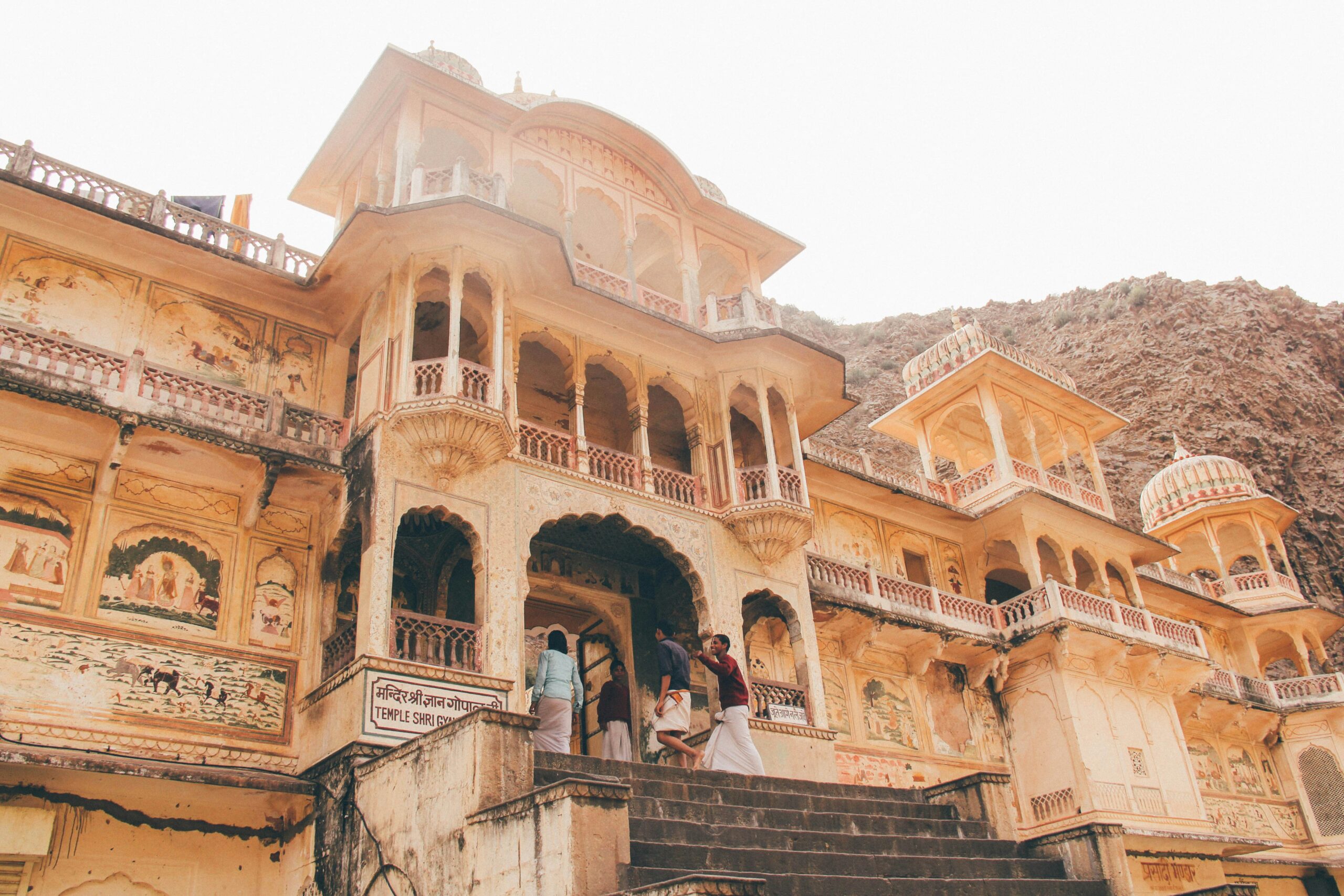 people entering the entrance of beige temple at daytime